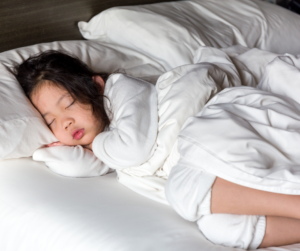 little girl sleeping peacefully in a bed